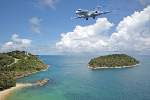 Private jet plane is going to land at the airport of a tropical