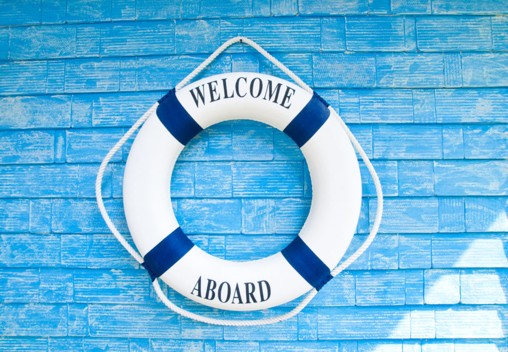 Life buoy with welcome aboard on it hanging on blue wall, welcome aboard, buoy, driftwood