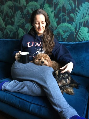 Dog sitter Amanda Walkins cuddling two puppies 
